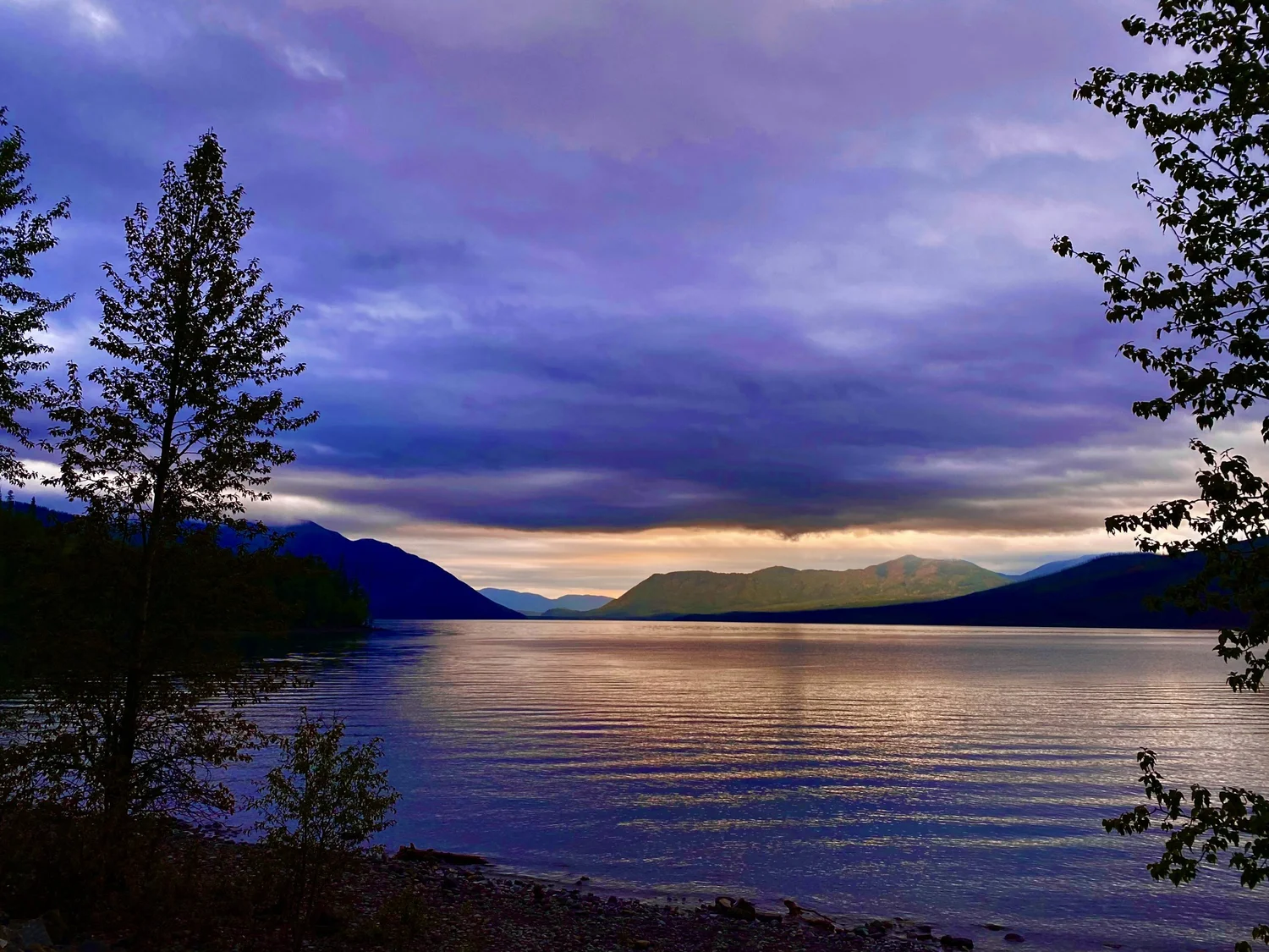 A still lake at sunset with mountains behind